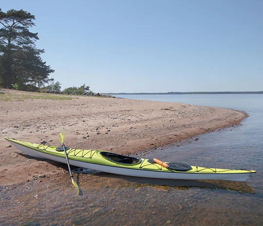 Grön kajak uppdragen på strand