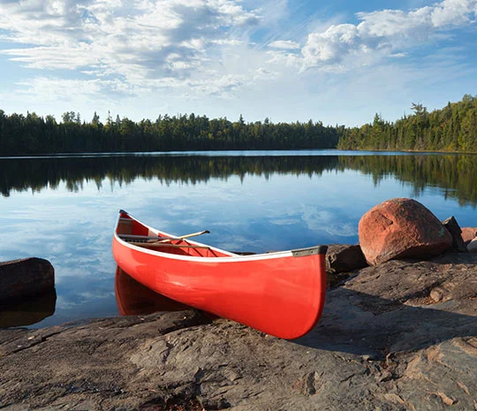 Röd kanot uppdragen på ett berg